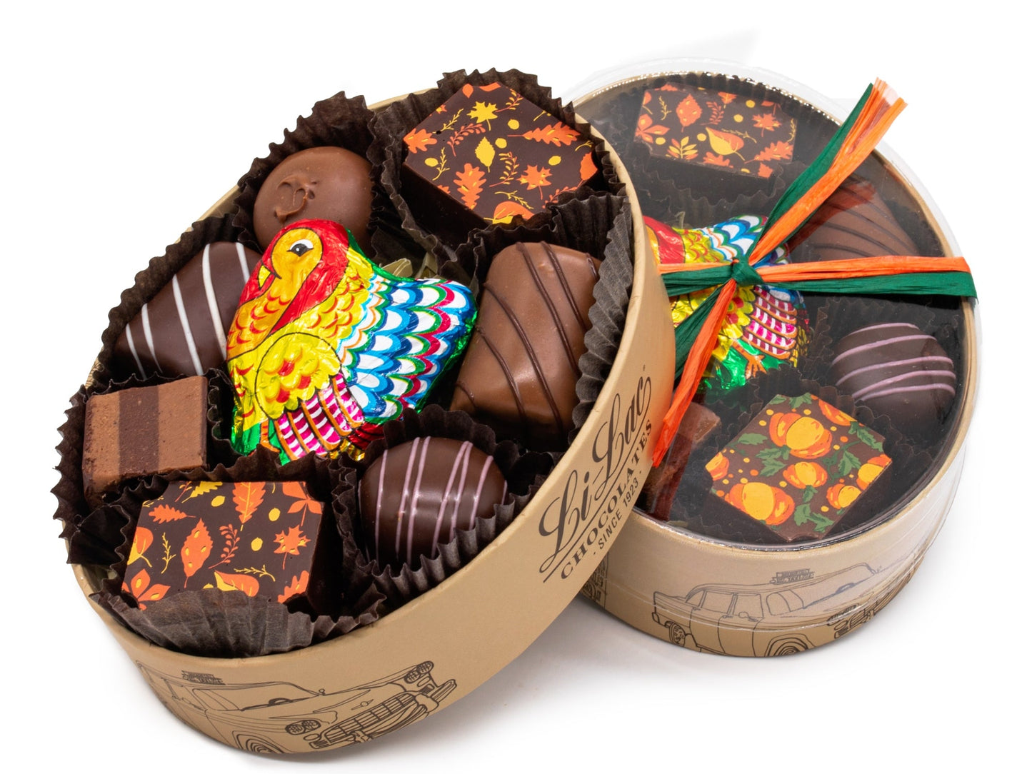 An oval box has 8 pieces of assorted chocolates plus a foil wrapped turkey in the center. It has a clear lid and is tied with autumnal raffia.