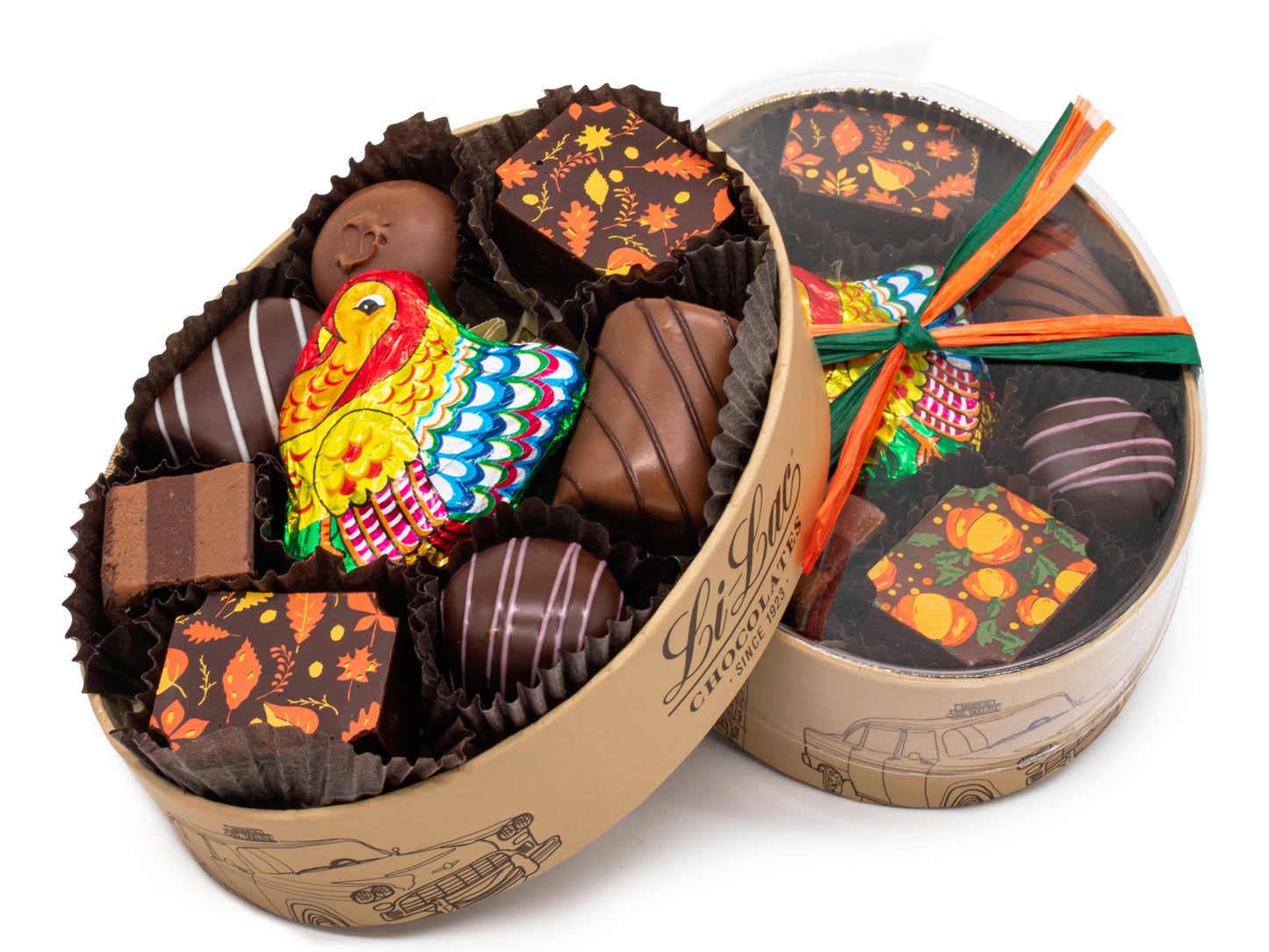 An oval box has 8 pieces of assorted chocolates plus a foil wrapped turkey in the center. It has a clear lid and is tied with autumnal raffia.
