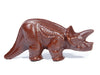 A three-dimensional triceratops molded out of chocolate. It has a big horn and a thick tail.