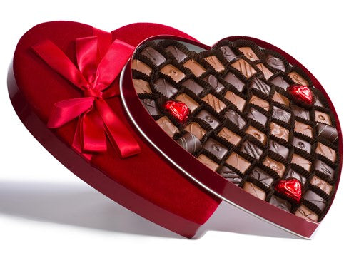 Sixty-three assorted chocolates sit inside a very large heart shaped box.