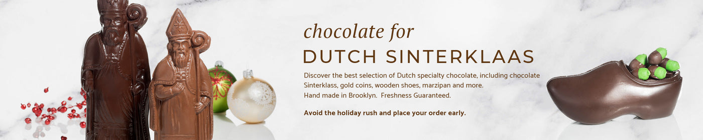 two chocolate dutch sinterklass with two christmas balls behind it and a chocolate wooden shoe filled with marzipan acorns.