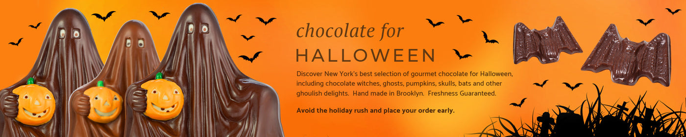 three chocolate ghosts and two chocolate bats on a spooky orange background with bats flying in the distance.