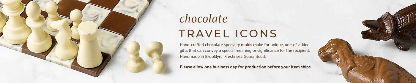 A chocolate chess set and two chocolate dinosaurs on a marble background.