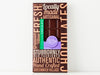 A handsome brown box with a bold graphic design and a window showing through to the chocolate bar