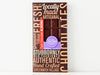 A handsome brown box with a bold graphic design and a window showing through to the chocolate bar