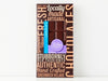 A handsome brown box with a bold graphic design and a window showing through to the chocolate bar