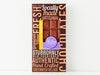 A handsome brown box with a bold graphic design and a window showing through to the chocolate bar