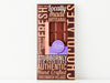 A handsome brown box with a bold graphic design and a window showing through to the chocolate bar