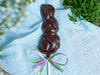 a chocolate bunny pop on a pastel blue cloth background