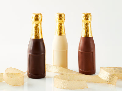 Three chocolate champagne bottles with a gold ribbon running throughout them