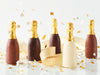 Five mini chocolate champagne bottles with confetti
