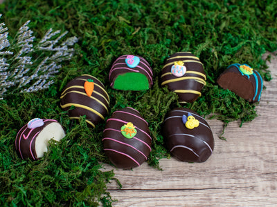 7 gourmet chocolate Easter eggs sitting on a bed of greens