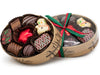 An oval box with a clear lid tied with a festive holiday ribbon, and filled with 8 pieces of assorted chocolates including a white chocolate snowman and red foiled chocolate star.