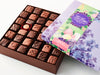 An open box showing the chocolate pieces with an Easter-motive sleeve on the box top