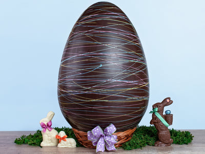 a very large chocolate egg decorated with colorful  drizzle