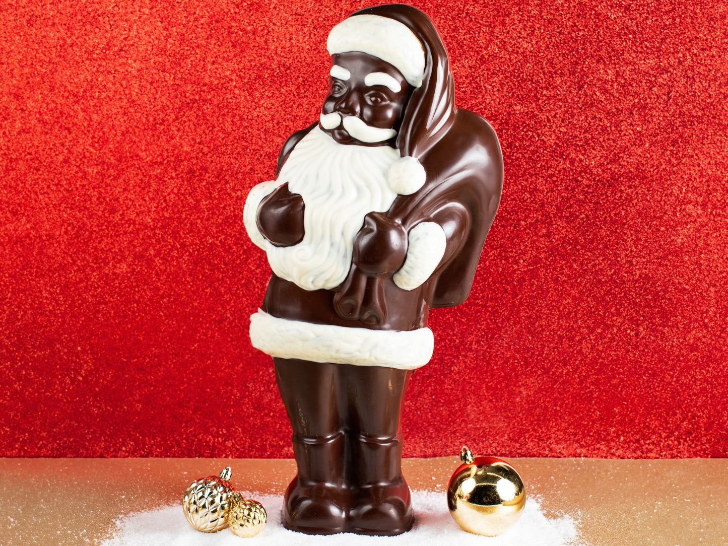 A large chocolate molded Santa Claus holds a toy sack over his shoulder.