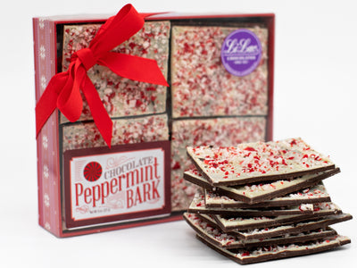 A Box filled with Peppermint Bark and a small stack of bark in front of the box.