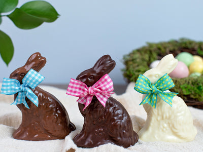 three chocolate place setting bunnies with Easter bows around their necks.