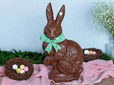 A large chocolate rabbit with pointy ears decorated with an Easter ribbon