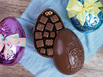 a large chocolate egg filled with assorted chocolates and covered in colorful foil.