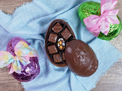 A medium sized dark chocolate egg filled with assorted chocolates.