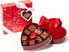 Ten assorted chocolates sit inside a heart shaped box. The square, outer box stands nearby.