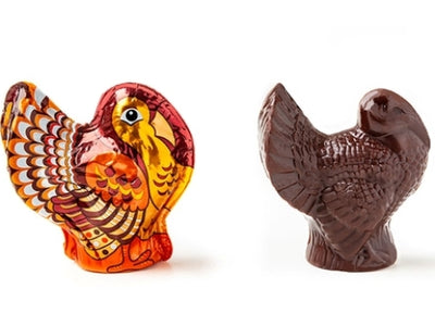 One foiled turkey stands next to an unwrapped chocolate turkey so that you can see the realistic detail of the chocolate mold. 