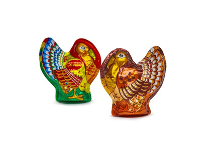 Two foiled chocolate turkeys stand next to one another. The milk chocolate turkey is blue, green, red, yellow and orange. The dark chocolate turkey is brown, gold, yellow, and orange.