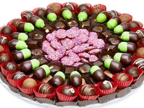 Layers of Gourmet Truffles, Marzipan Acorns, Nonpariels and assorted chocolate squares are grouped beautifully on a round platter.