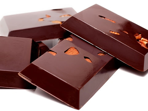 Small rectangular bars of 72% dairy-free dark chocolate are stacked up together. Almonds are visible in the chocolate bars.