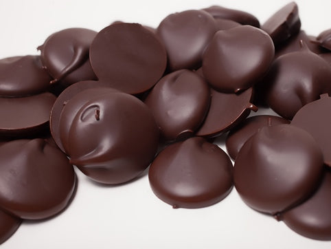 Small dollops of dark chocolate sit together.
