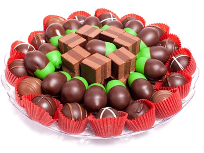 Hazelnut Truffle Squares, Marzipan Acorns and Gourmet Truffles sit, stacked beautifully on a serving tray.