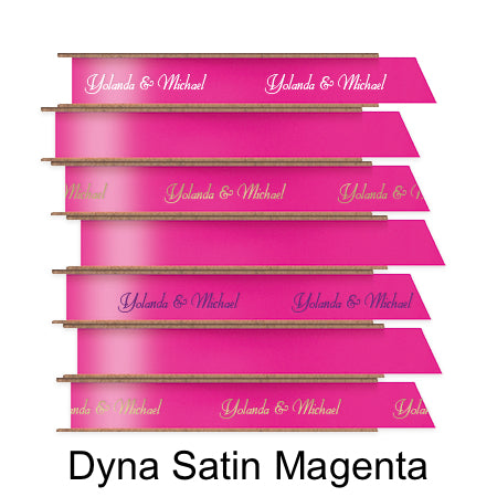 A stack of seven spools of shiny bright magenta pink satin ribbon with custom messages printed on them in different colors. 