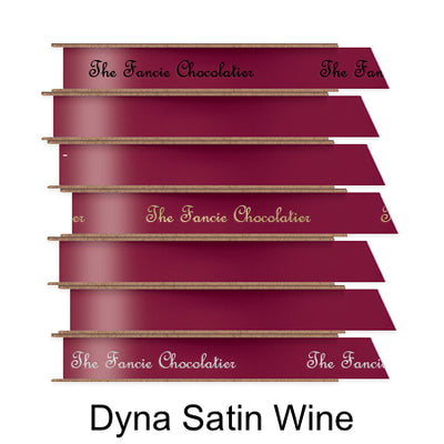 A stack of seven spools of shiny wine satin ribbon with custom messages printed on them in different colors. 