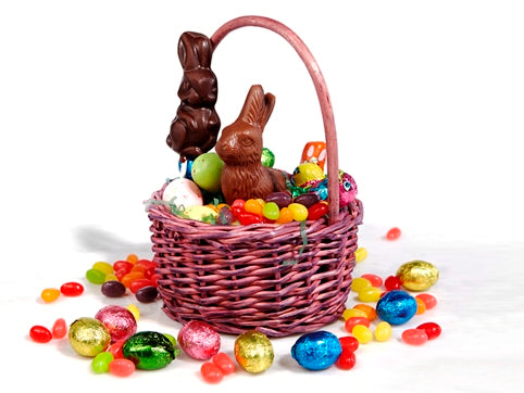 A small wicker basket is filled with Easter chocolates and candy.