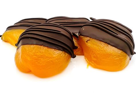 Four candied peaches are half dipped in dark chocolate with a dark chocolate drizzle.