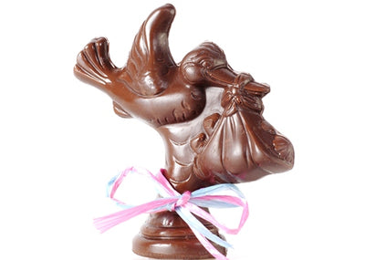 Chocolate molded into the shape of a flying stork carrying a baby in a blanket in its beak.