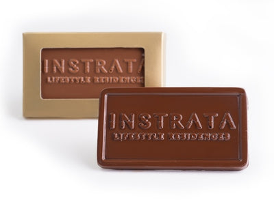 A small business card sized chocolate bar molded with your business logo fits perfectly into a small gold box. The box has a cellophane window that displays the chocolate logo.