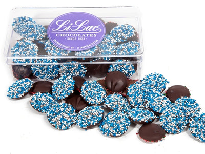 Chocolate nonpareils with blue and wite colored candy dots are inside a clear box.