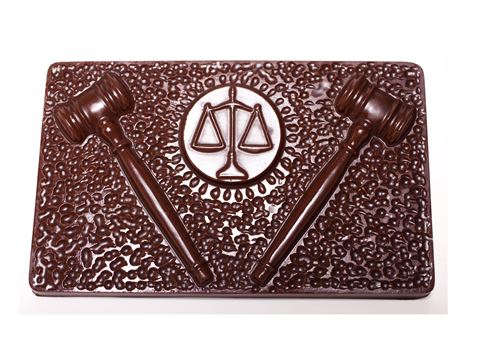 A Chocolate bar has a textured top and two gavels that flank the scales of justice symbol in a circle in the middle.