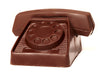 Old fashioned rotary phone with round dial is molded from chocolate.