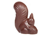 A molded chocolate squirrel has a fluffy tail and is nibbling on an acorn.