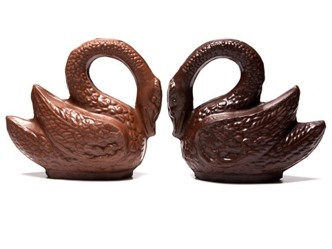 Three dimensional molded chocolate swans have long arched necks.