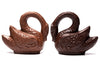 Three dimensional molded chocolate swans have long arched necks.