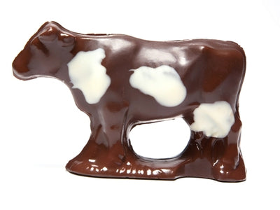 A dark chocolate, three-dimensional cow with white chocolate spots.