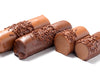 Little cylindrical rolls of chocolate mousse ganache are lined up together. They are covered in milk chocolate and coated with tiny chocolate sprinkles. One log is cut in half revealing the soft mousse interior.