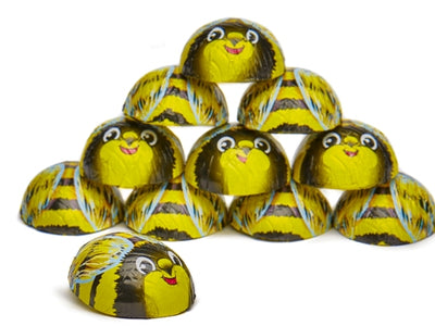 Chocolates wrapped in foil that have a decoration that makes them look like little round smiling bumblebees.