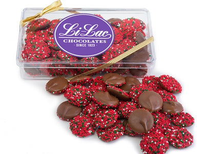 Chocolate nonpareils with red, green and white nonparel candies are inside a clear box. 
