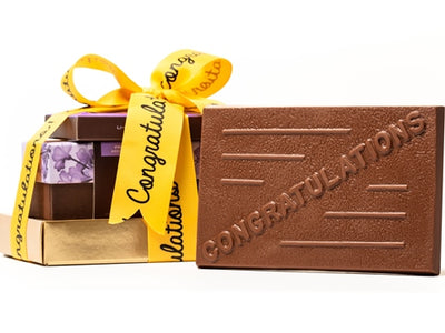 The congratulations bar is part of a bundle of gifts stacked together and tied with a yellow congratulations ribbon.