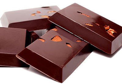 Small rectangular bars of 72% dairy-free dark chocolate are stacked up together. Almonds are visible in the chocolate bars.